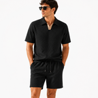 Black textured short sleeve polo shirt and matching shorts, front view.
