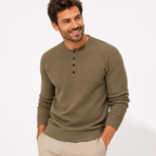Man wearing a green henley sweater on a white background