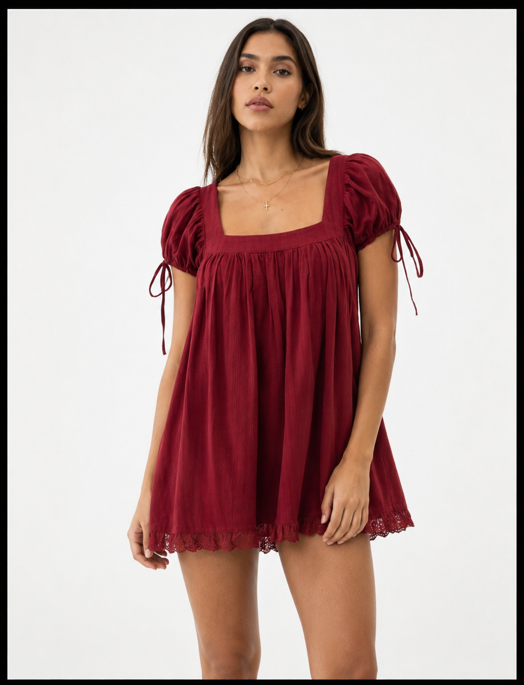 Woman wearing a burgundy dress with puff sleeves on a white background