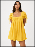 Woman wearing a yellow dress with puff sleeves on a white background